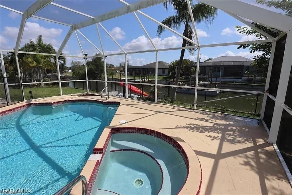 View of swimming pool featuring a sunroom, a lanai, a patio, and a pool with connected hot tub