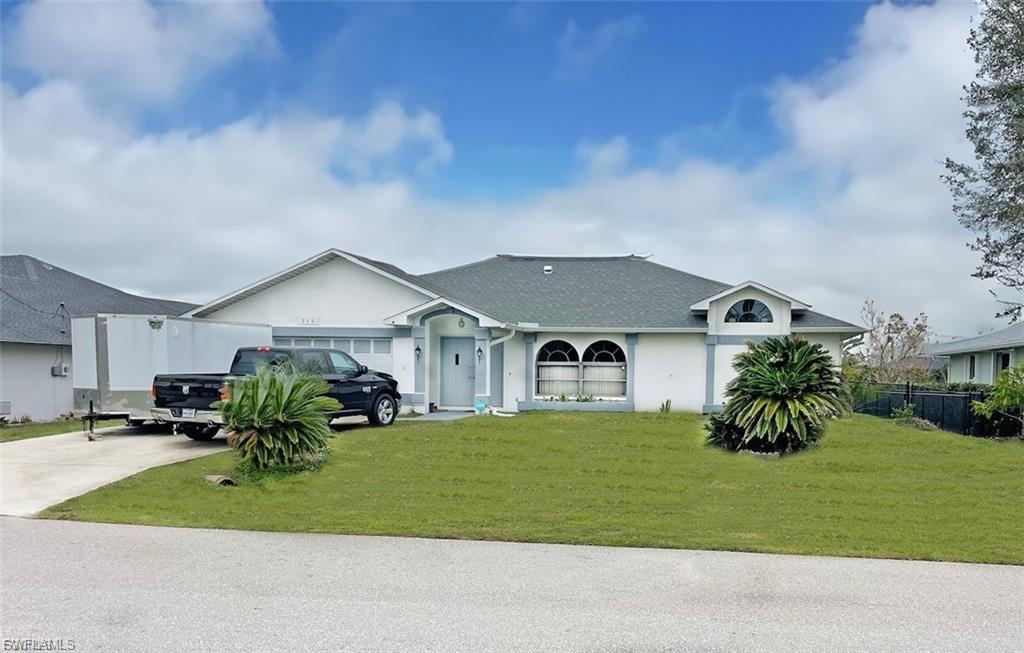 Single story home featuring driveway, stucco siding, and an attached garage