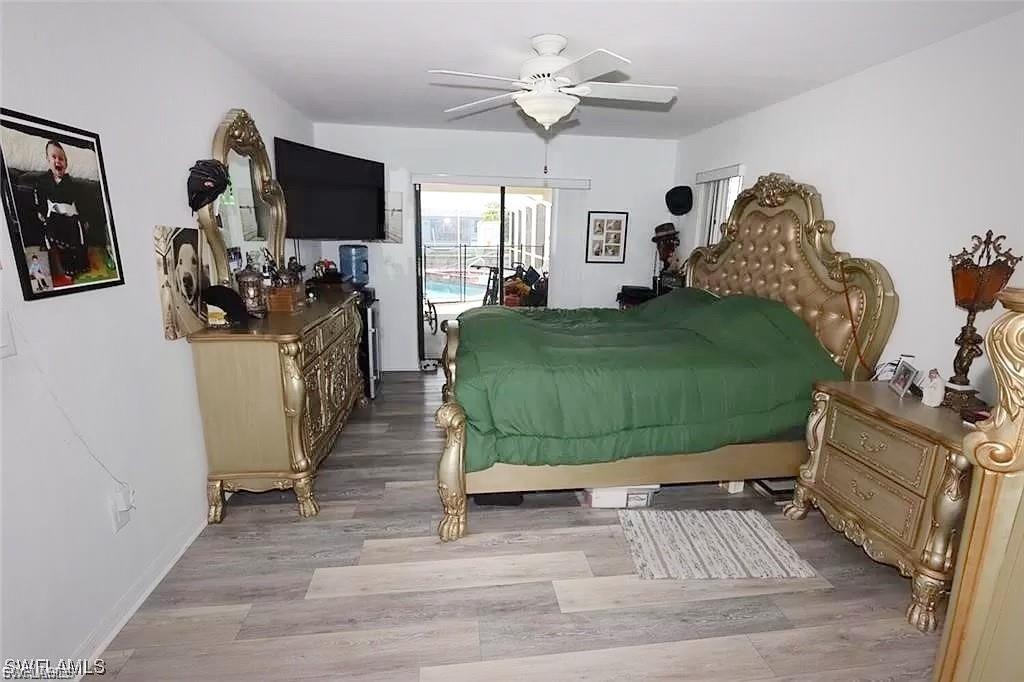 Bedroom featuring access to outside, light wood-style floors, and a ceiling fan
