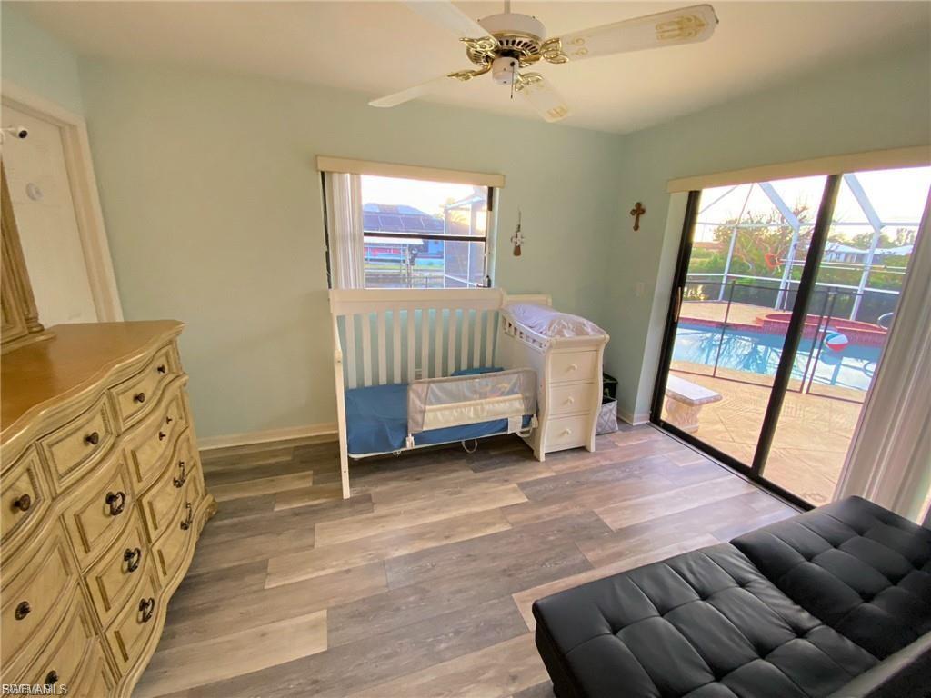 Bedroom featuring light wood finished floors, access to exterior, and multiple windows