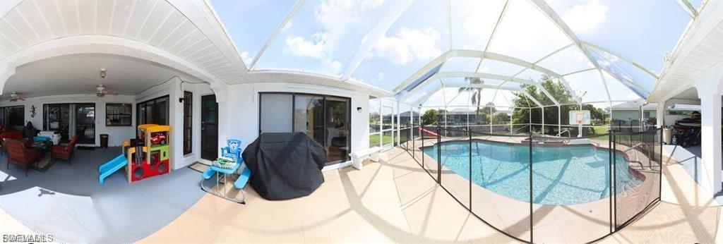Swimming pool featuring a sunroom, a patio area, grilling area, and a lanai