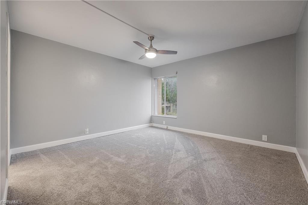 Unfurnished room featuring light colored carpet and ceiling fan