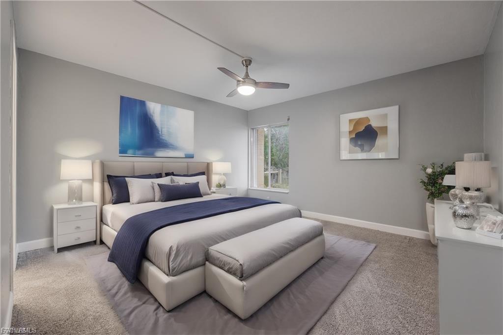 Carpeted bedroom with ceiling fan and baseboards
