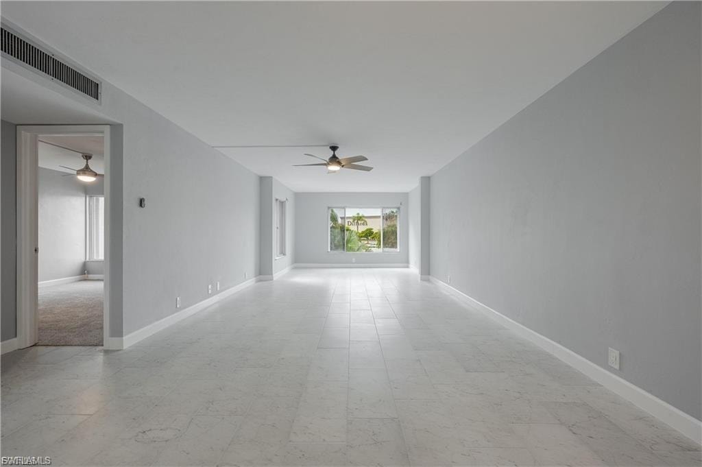 Empty room with light flooring and ceiling fan