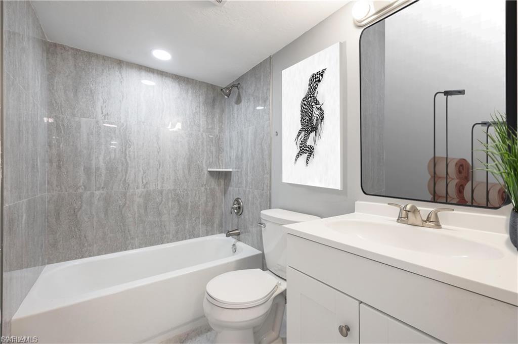 Bathroom with vanity, bathtub / shower combination, and recessed lighting