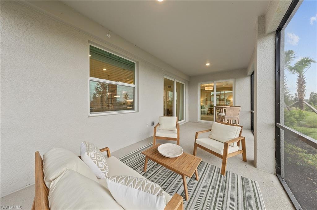 Sunroom featuring a textured wall, an outdoor living space, and recessed lighting