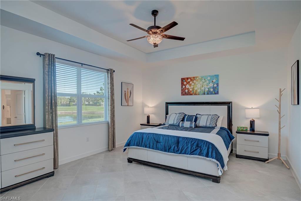 Bedroom featuring a raised ceiling and a ceiling fan