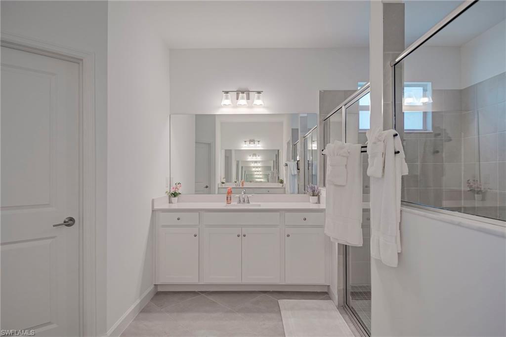 Bathroom featuring vanity, a shower stall, and light tile patterned flooring