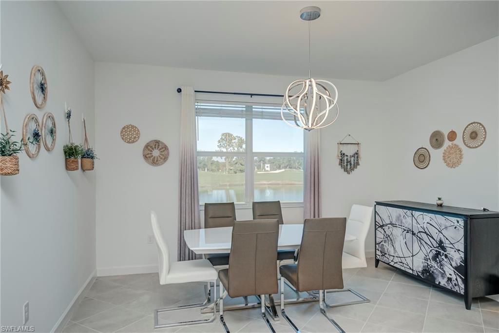 Dining area with a water view, a chandelier, and light tile patterned floors