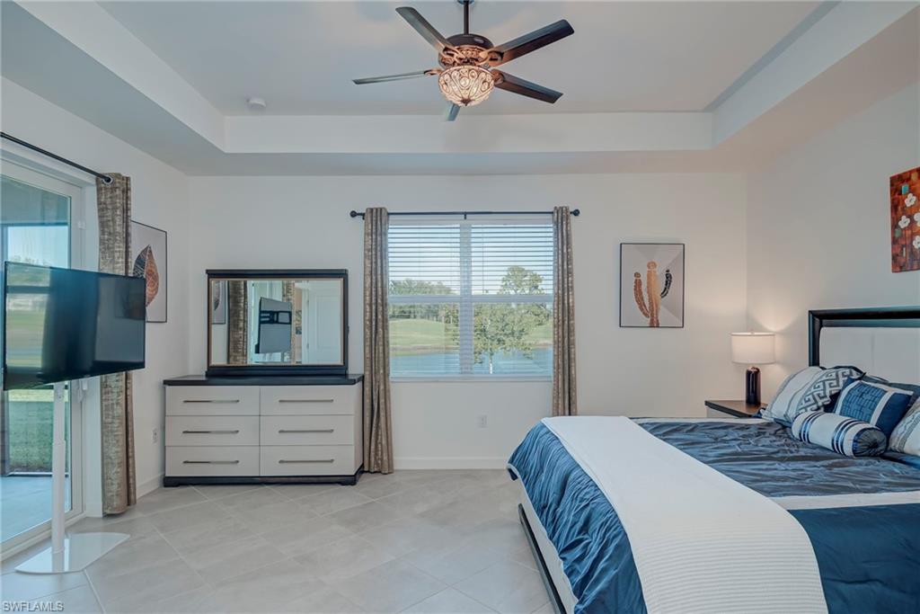Bedroom featuring a raised ceiling, a ceiling fan, and access to outside