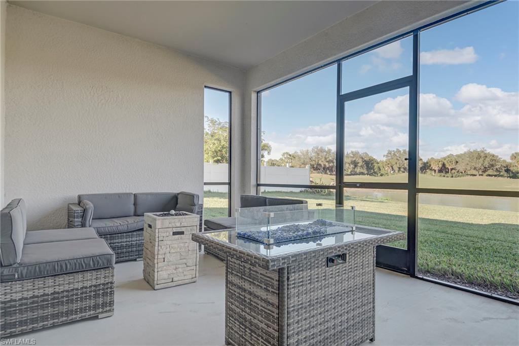 Sunroom featuring an outdoor living space with a fire pit and a water view