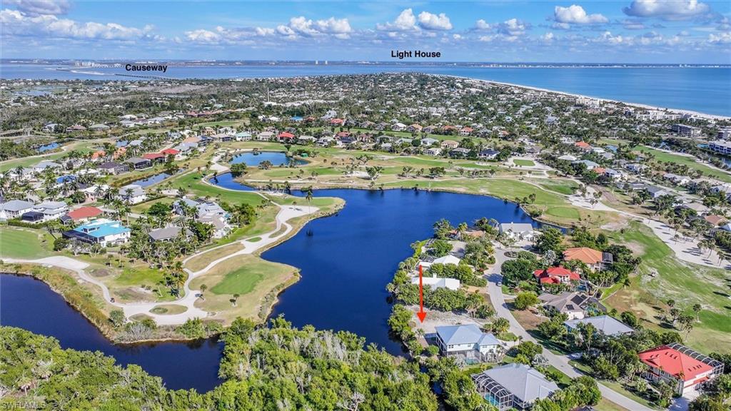 Aerial perspective of suburban area featuring a nearby body of water and a local golf course