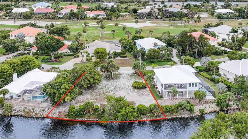 Aerial view of residential area featuring property parcel outlined and a nearby body of water