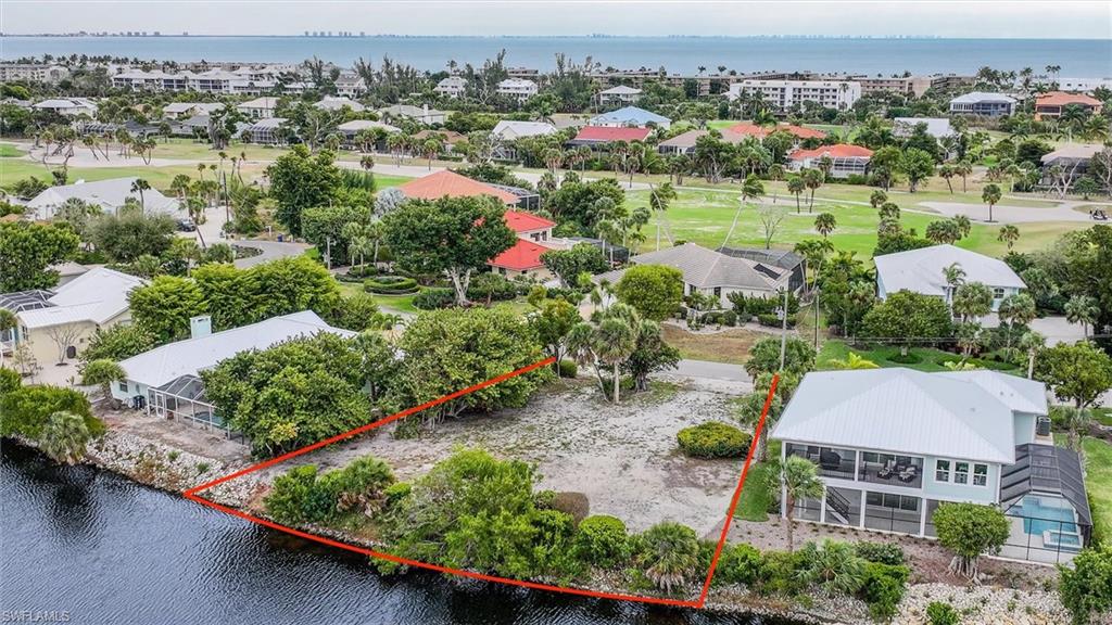 Aerial perspective of suburban area with a large body of water and property parcel outlined