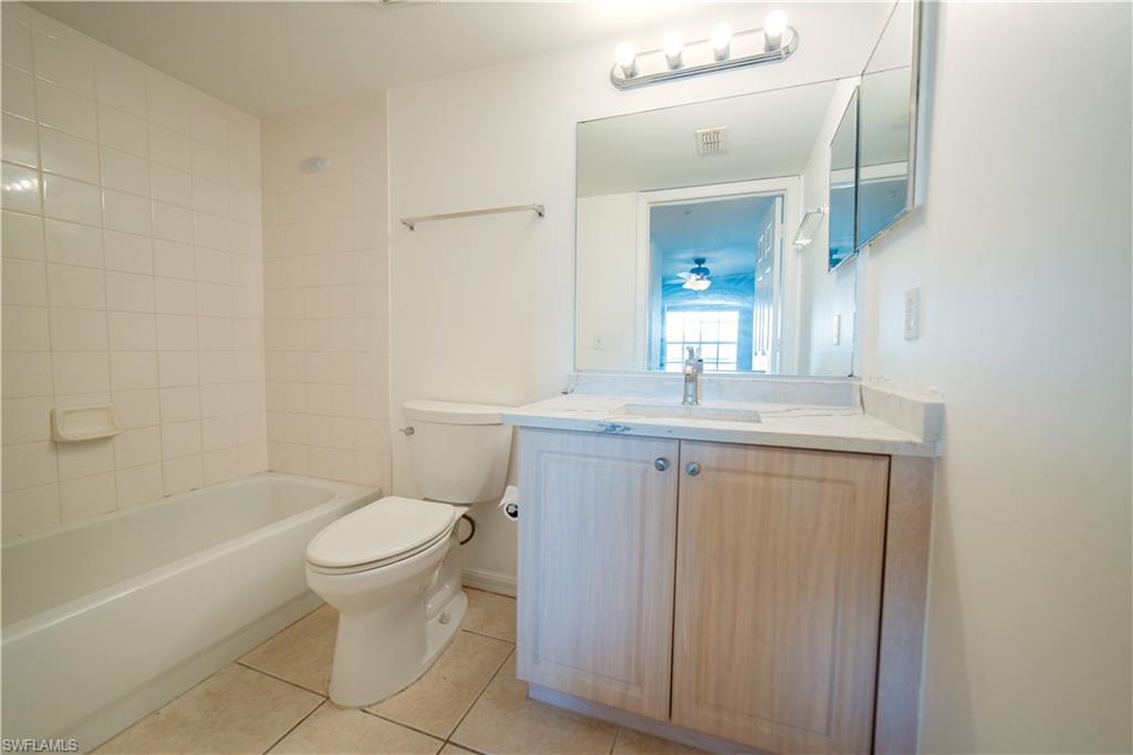 Primary Bathroom with vanity, light tile patterned floors, and tub / shower combination