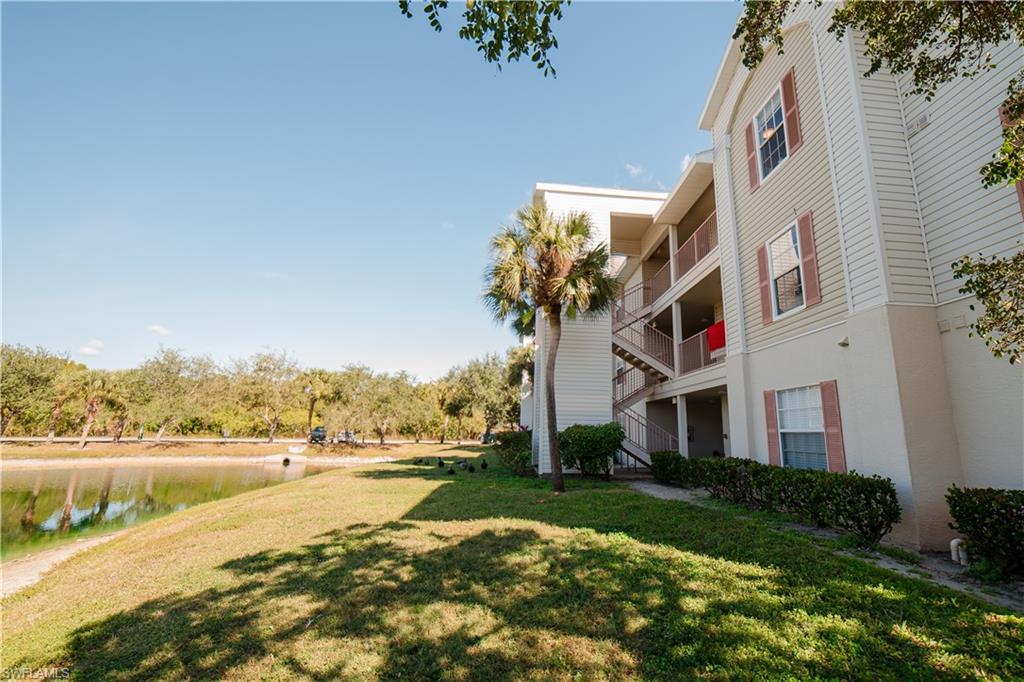 View of home's community featuring a lawn, a water view, and a balcony