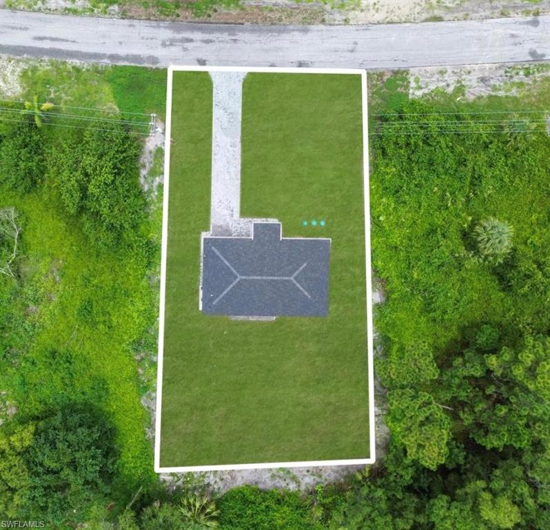 Aerial view of property and surrounding area featuring property parcel outlined