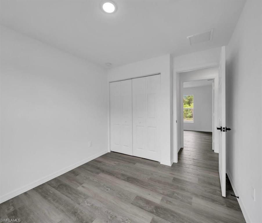 Unfurnished bedroom featuring a closet and wood finished floors