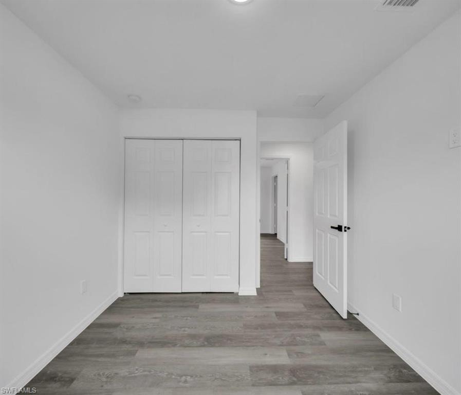 Unfurnished bedroom featuring wood finished floors and a closet