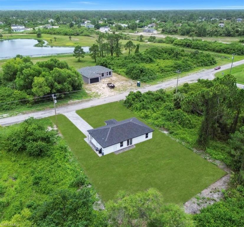 View from above of property featuring a large body of water and a tree filled landscape