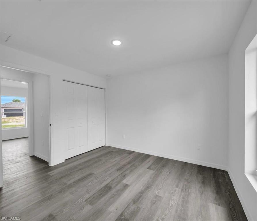Unfurnished bedroom featuring a closet, light wood-style floors, and recessed lighting