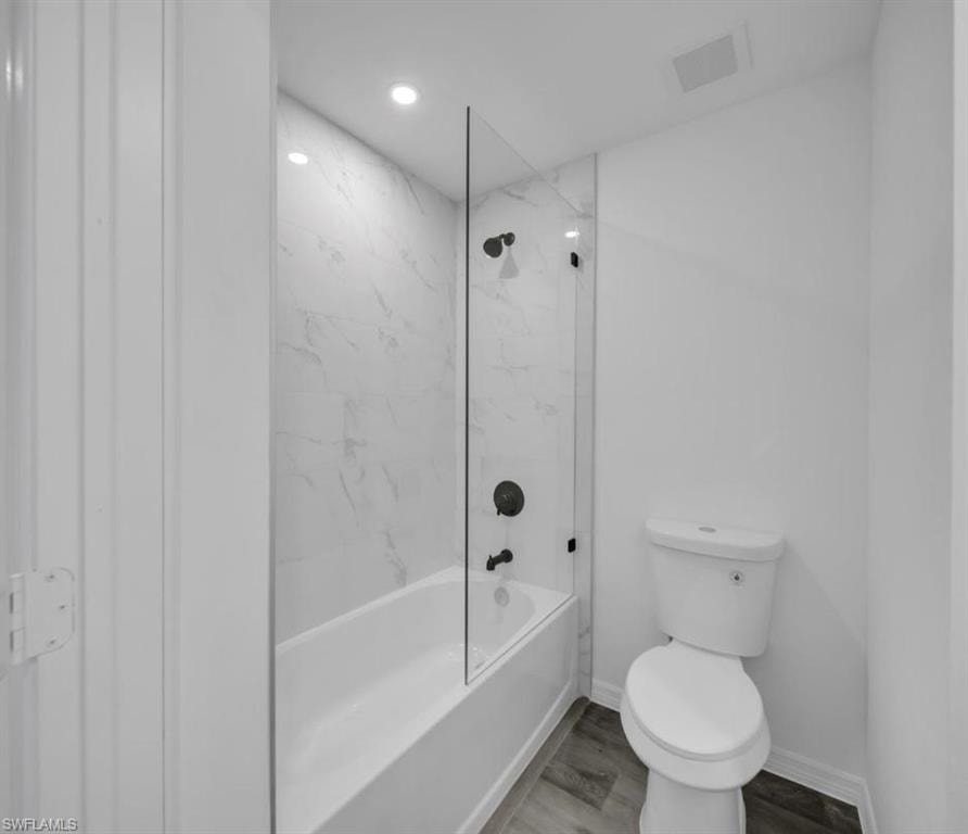 Full bathroom featuring bathtub / shower combination, wood finished floors, and recessed lighting