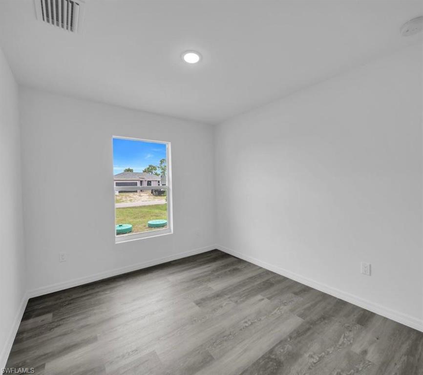 Empty room featuring light wood-type flooring and a smoke detector