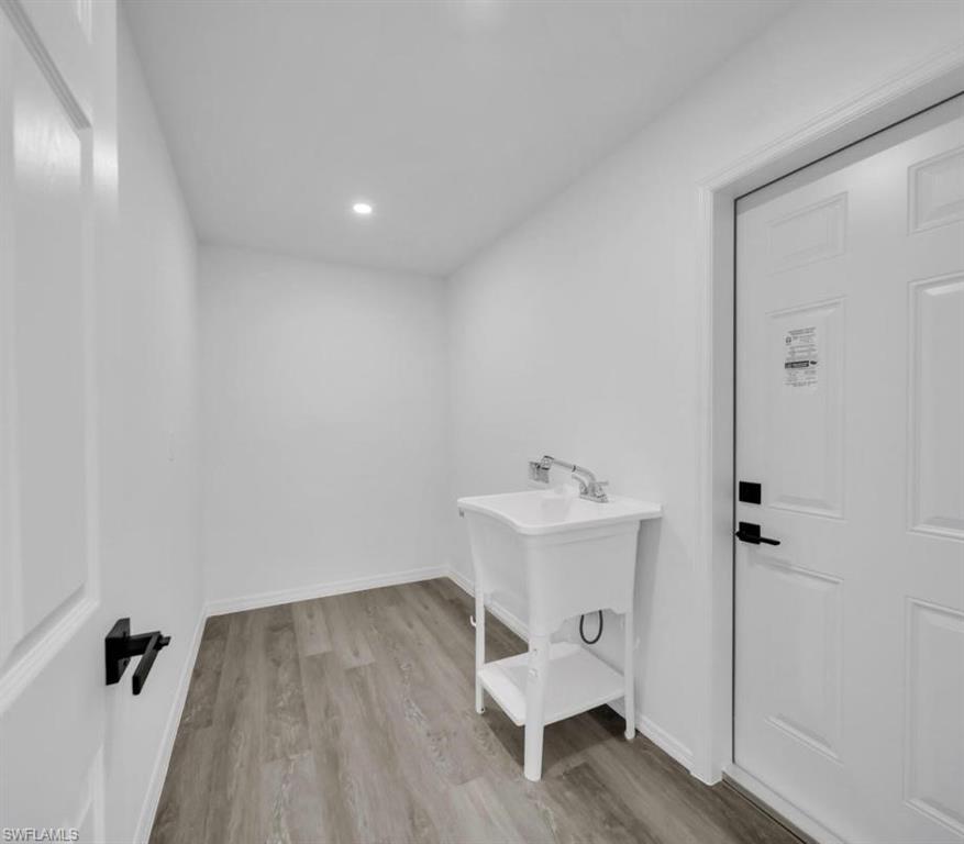 Laundry room with light wood-style floors and baseboards