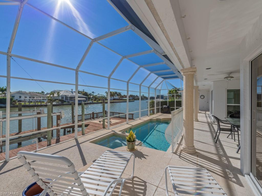 Outdoor pool featuring a sunroom, a lanai, a patio area, and a dock
