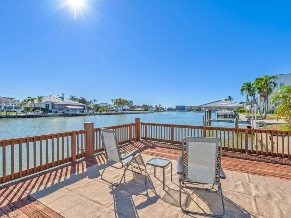 Dock featuring boat lift and a deck with water view