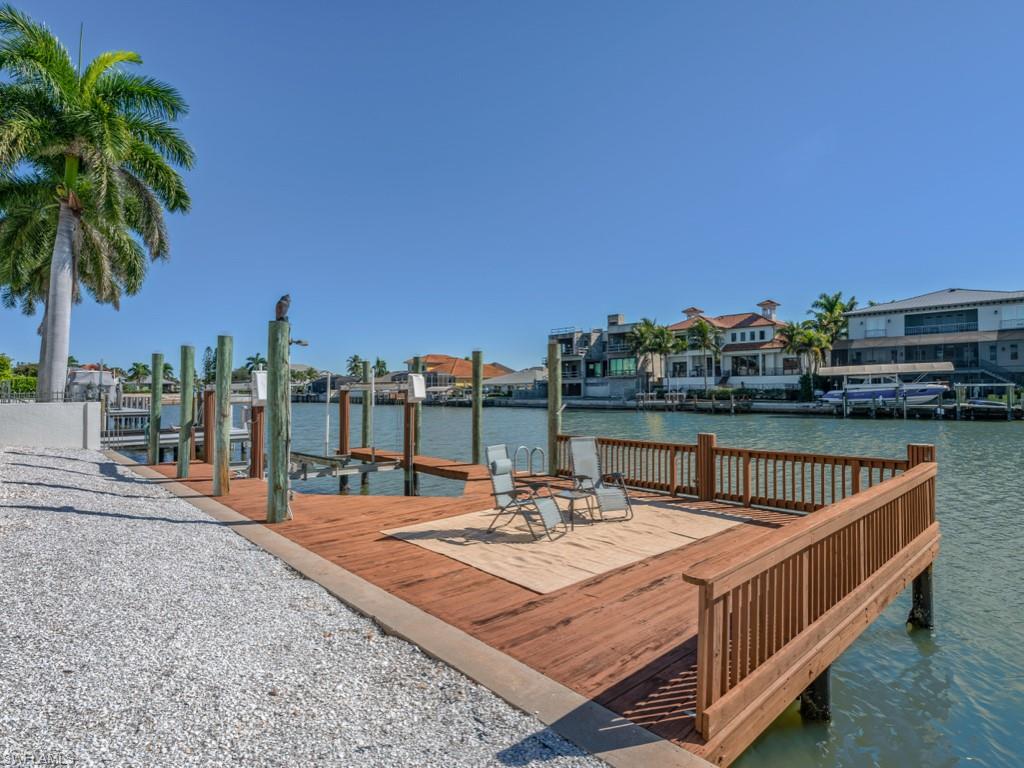 Dock area featuring a water view, a residential view, and boat lift