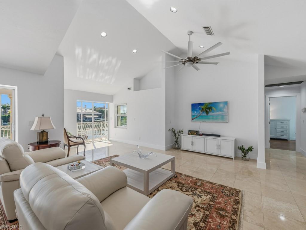 Living area with high vaulted ceiling, recessed lighting, and ceiling fan