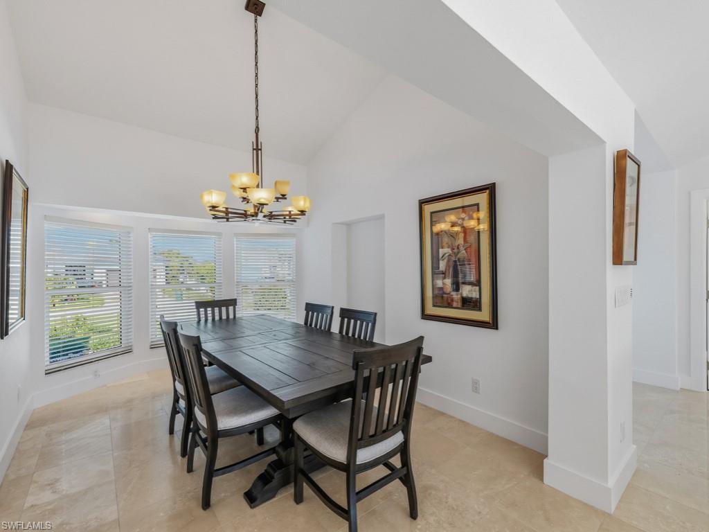 Dining room with a chandelier and high vaulted ceiling