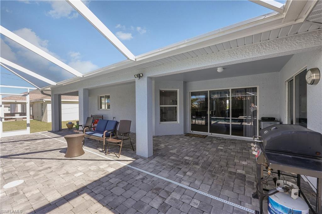 View of patio with a grill and a lanai