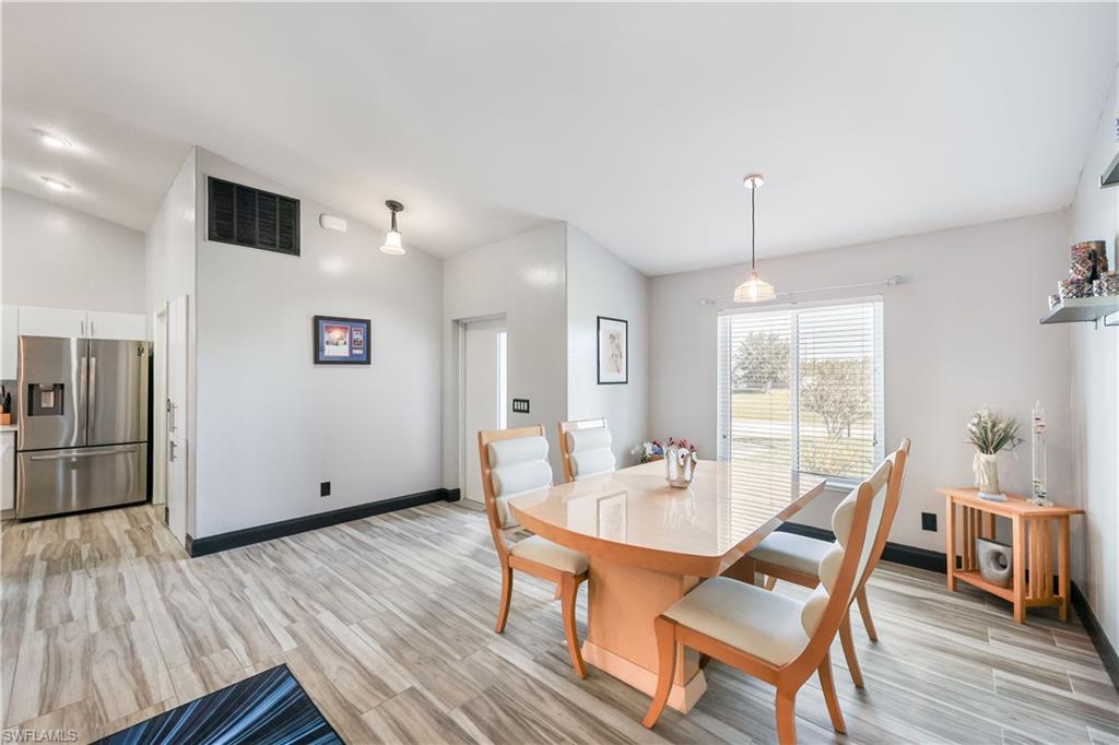 Dining room featuring light wood-style floors and high vaulted ceiling