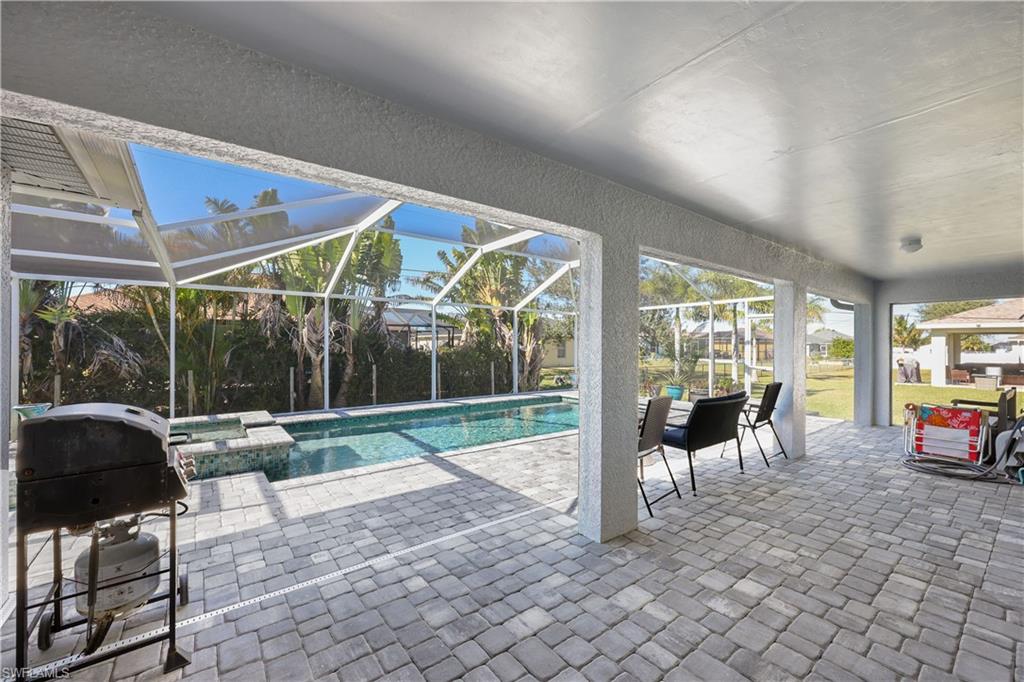 Outdoor pool featuring a grill, a patio area, a lanai, and a sunroom