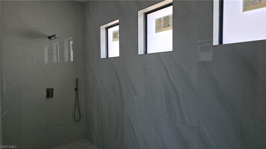 Bathroom featuring a marble finish shower