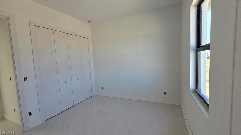 Unfurnished bedroom featuring a closet and concrete flooring