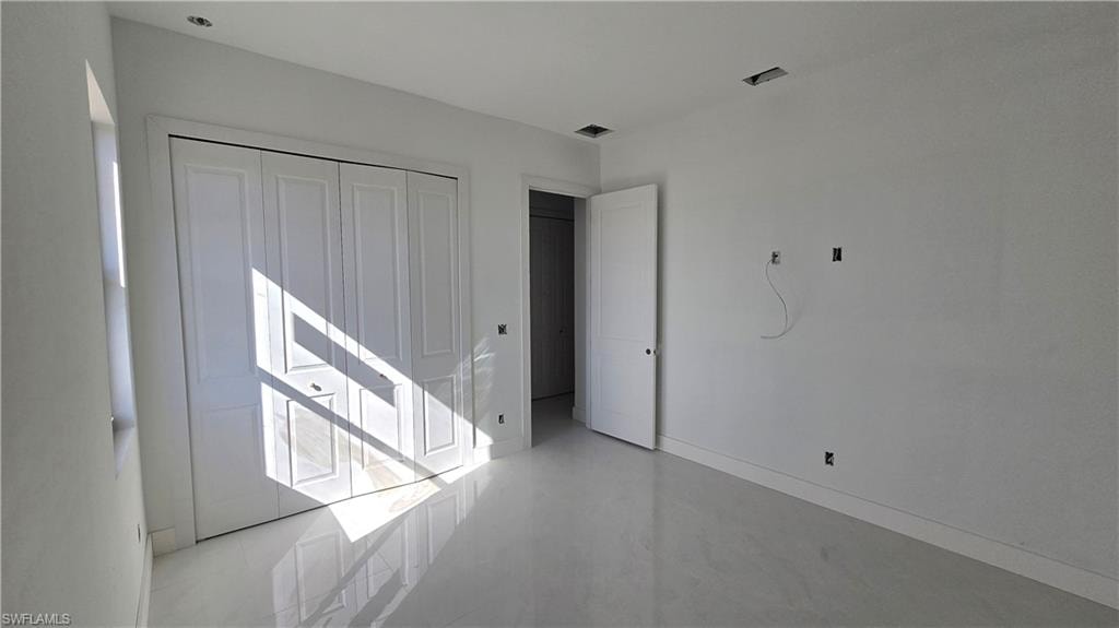 Unfurnished bedroom featuring a closet and baseboards