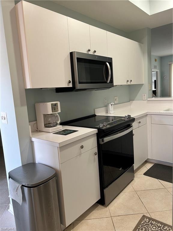 Kitchen featuring white cabinets, light countertops, and tile flooring