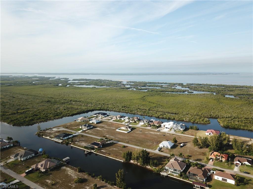 Aerial view of property and surrounding area featuring a nearby body of water and nearby suburban area