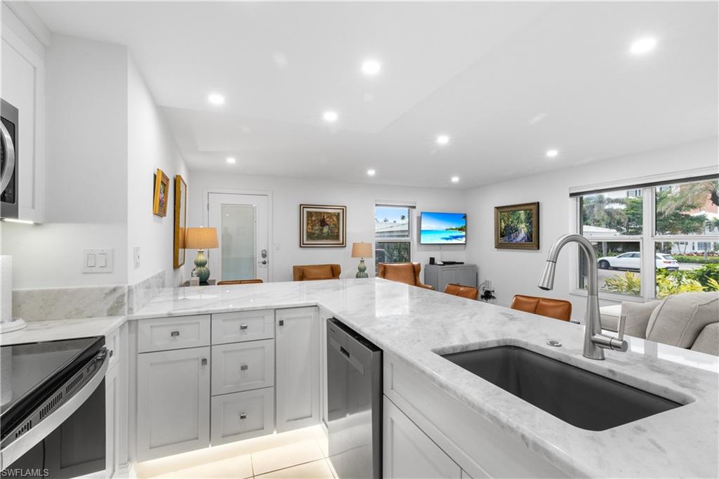 Kitchen photo showing counter tops, range, microwave, dishwasher and under-counter over-sized sink.