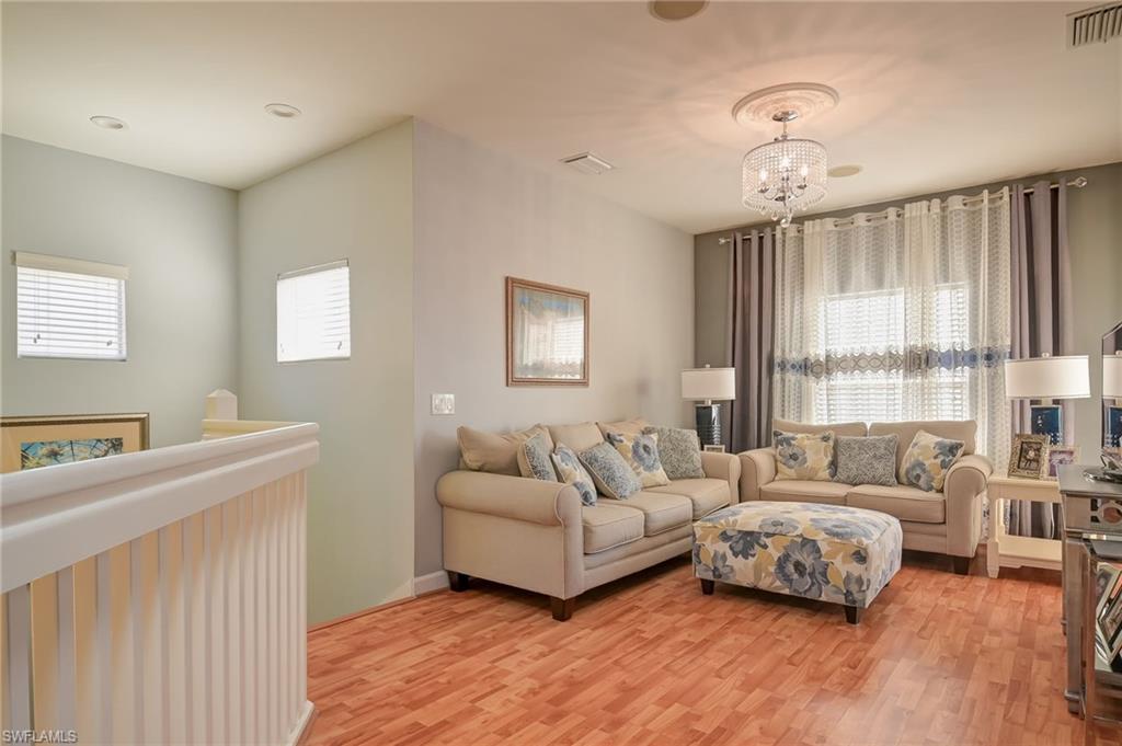 Living room with light wood-type flooring and a chandelier