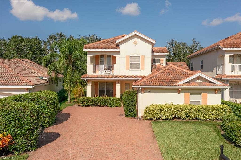 Mediterranean / spanish-style home with a tile roof, stucco siding, a balcony, and a front yard