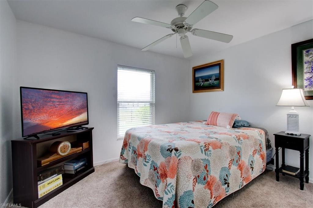 Carpeted bedroom featuring a ceiling fan