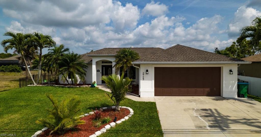 View of front of property featuring driveway, roof with shingles, stucco siding, and a garage