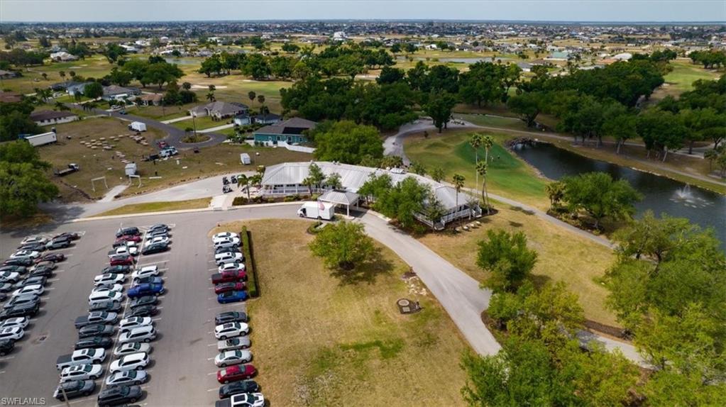 Aerial view of property and surrounding area with a large body of water and a golf course
