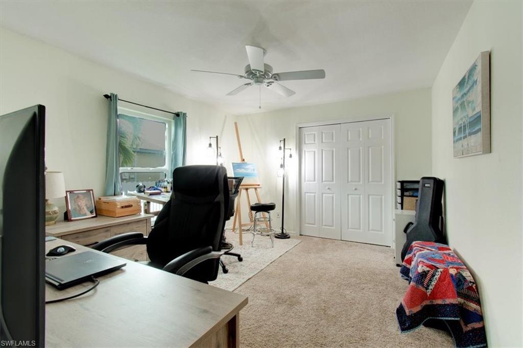 Office space with light colored carpet and a ceiling fan