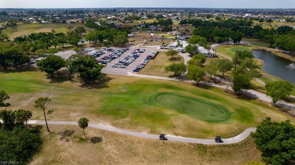 Aerial overview of property's location featuring a golf course and a large body of water