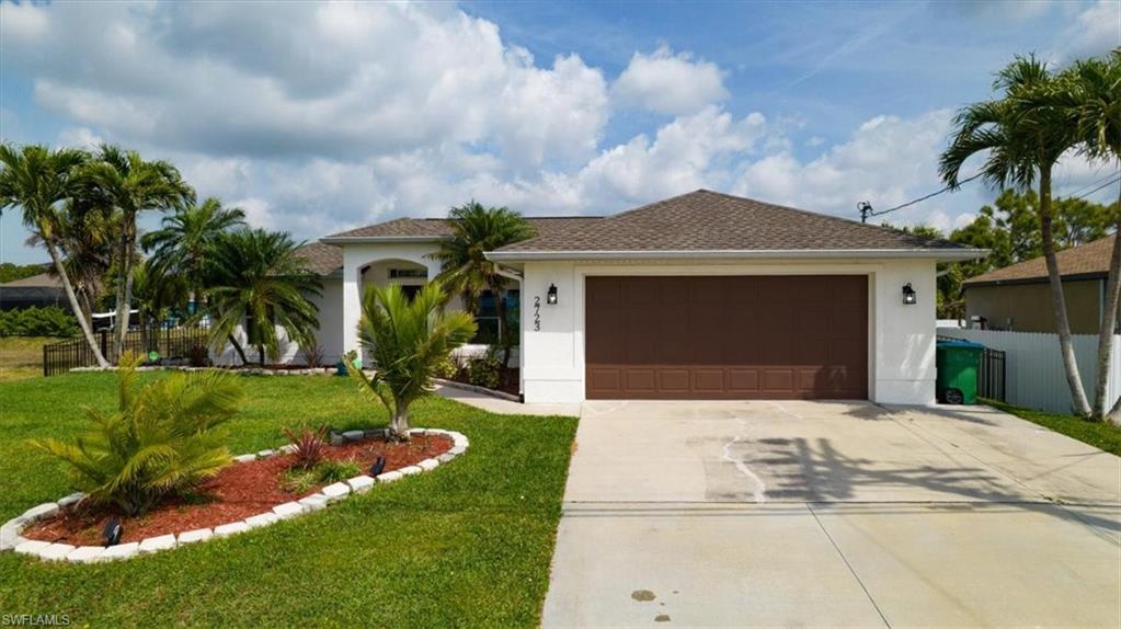 View of front of house with concrete driveway, a garage, roof with shingles, and stucco siding